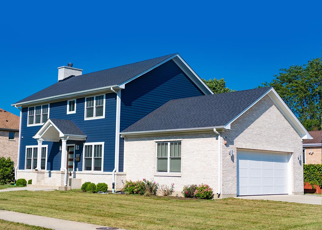 A blue and white modern, suburban home in a residential neighborhood.