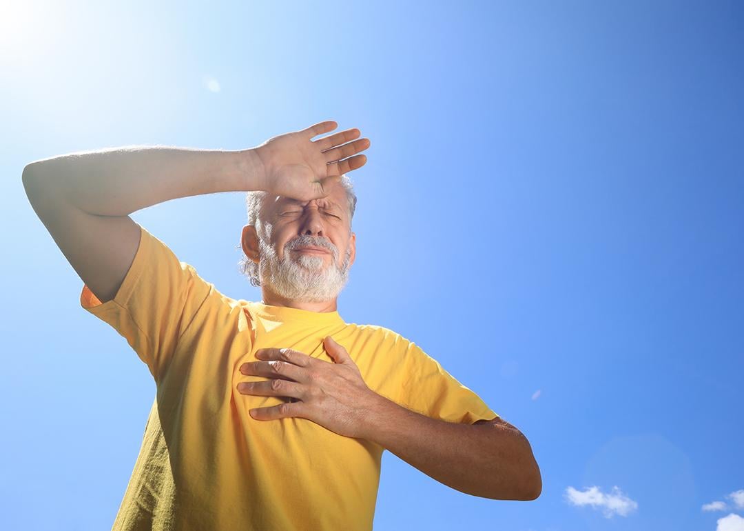 A senior man suffering from heat stroke while outdoors under the sun.