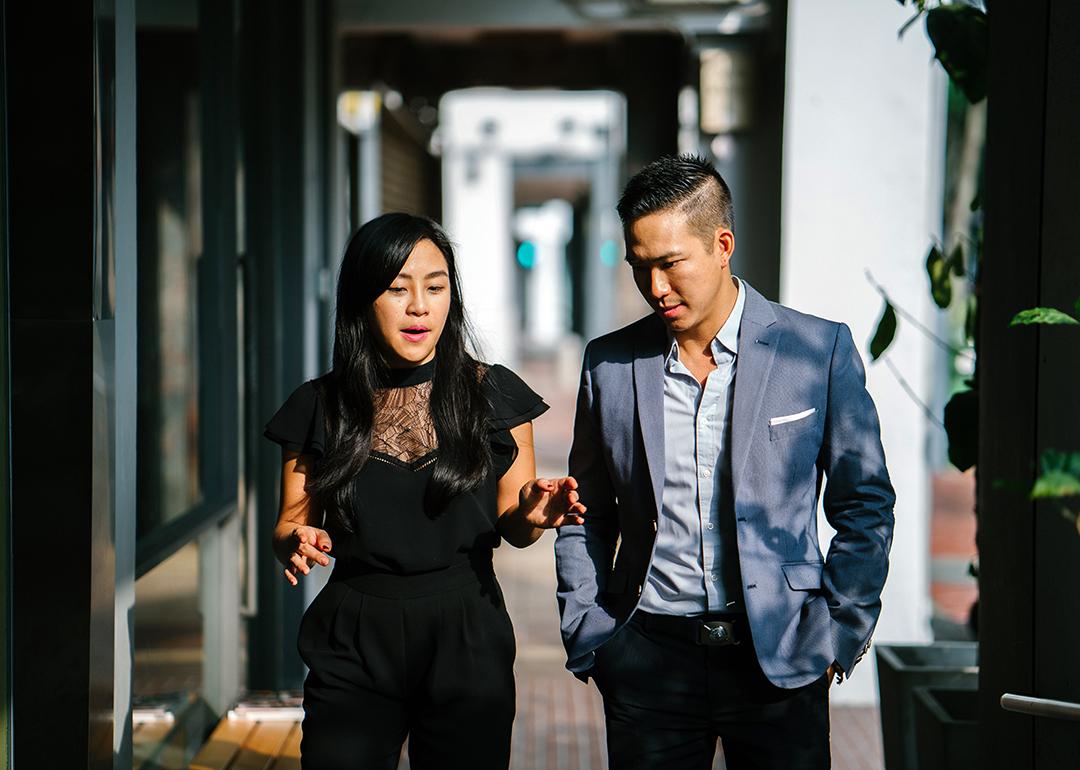 A pair of business people walking along a corridor.