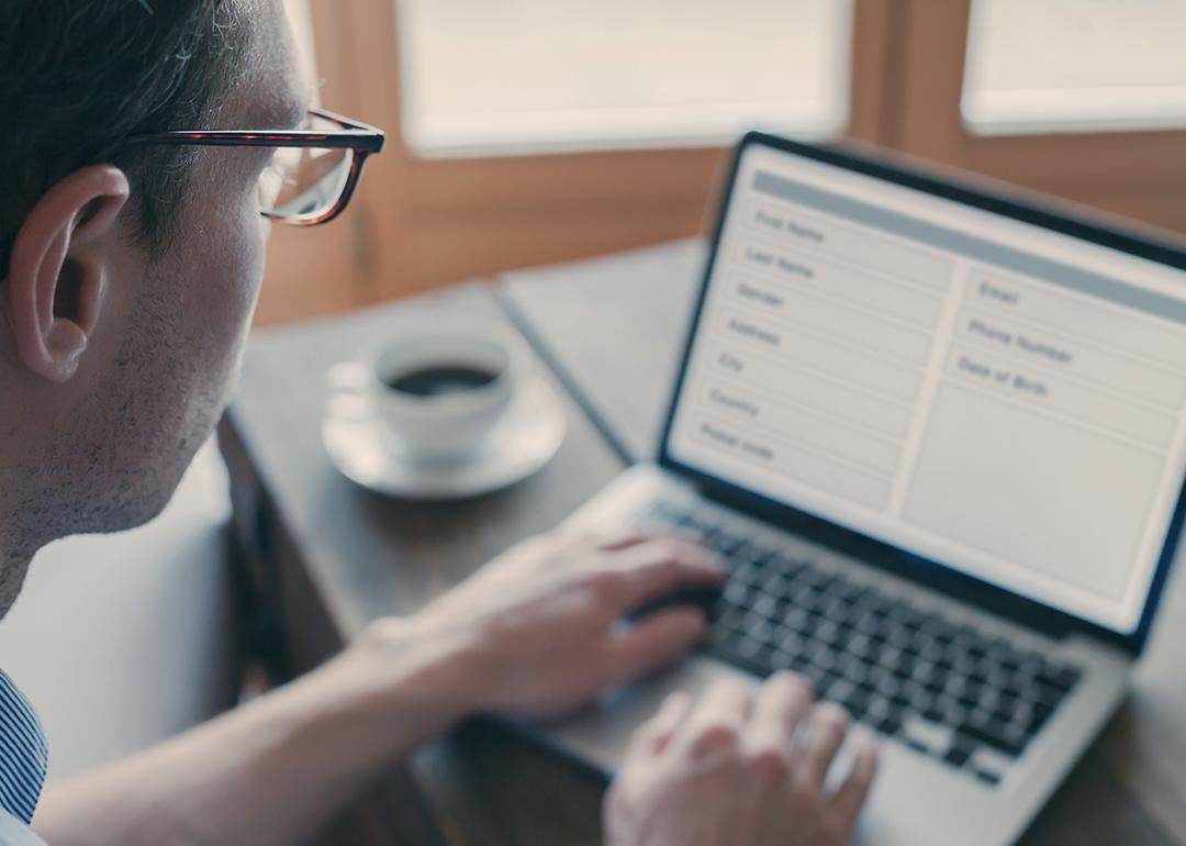 Man using laptop at home to fill out a form online.