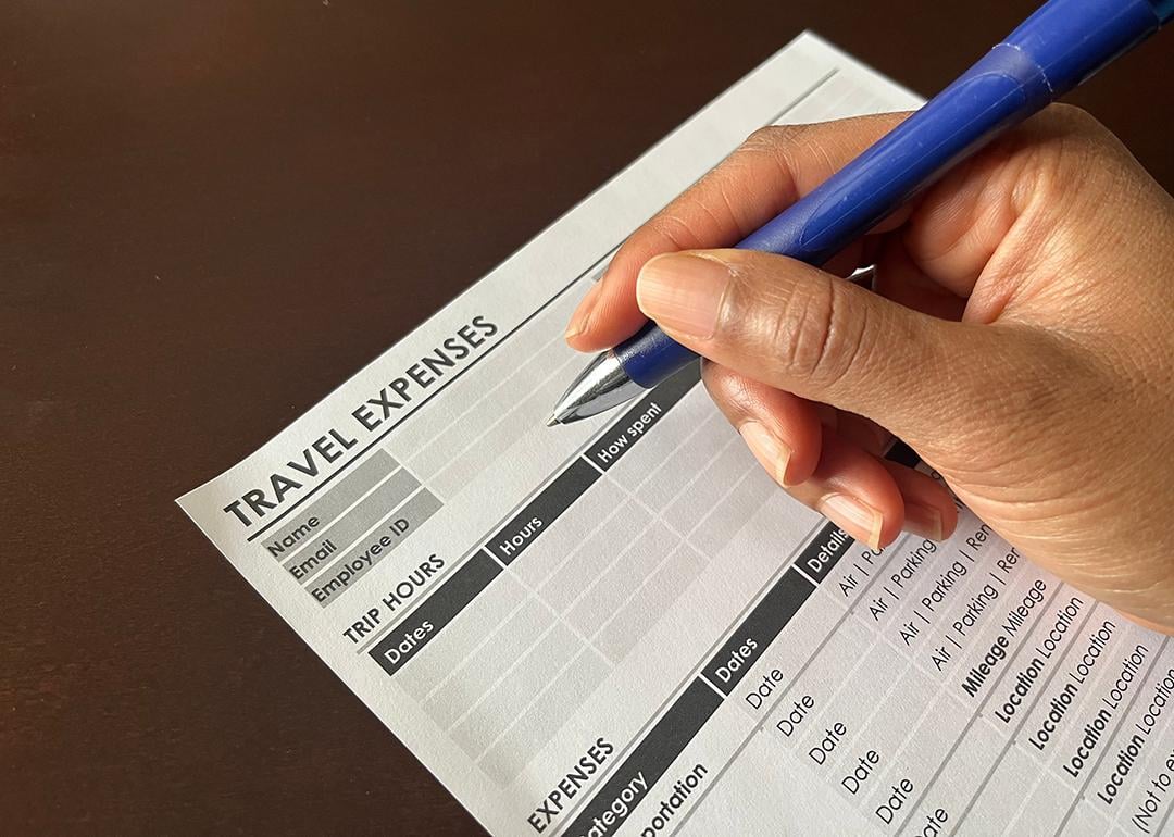 Person completing a travel expense form.