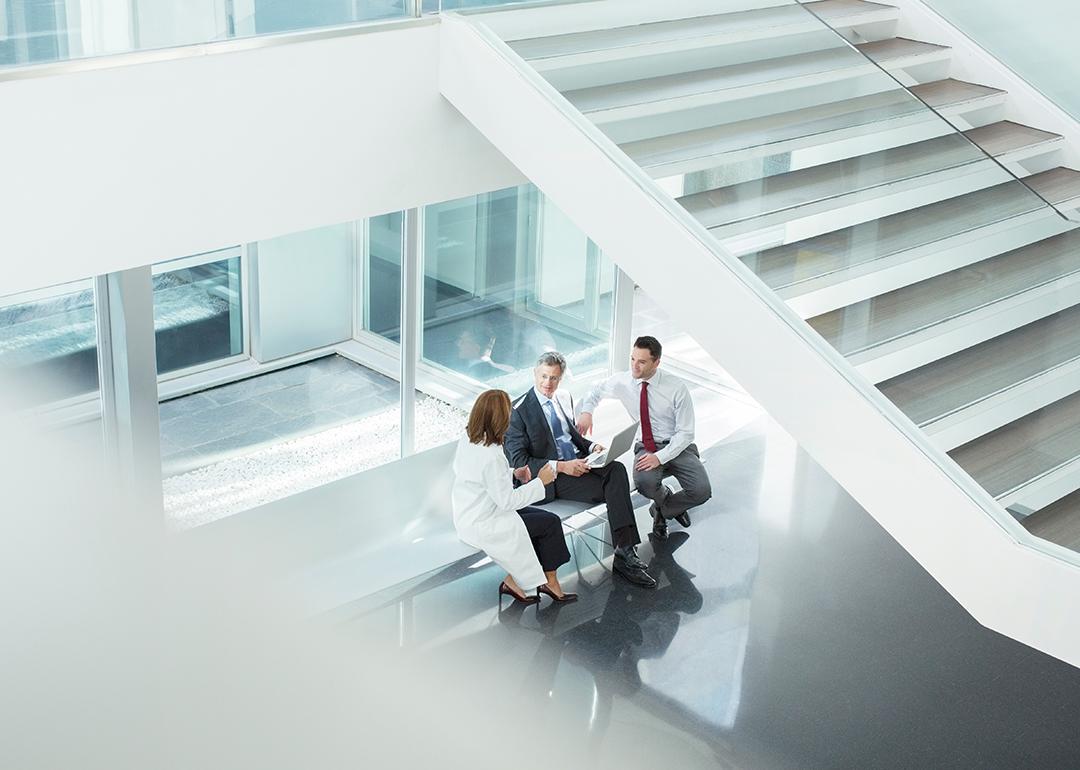 A doctor and administrators talking in a hospital lobby.