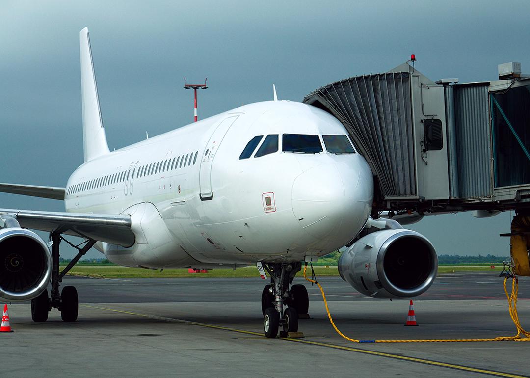 A charter airline airplane parked and connected to a boarding bridge.