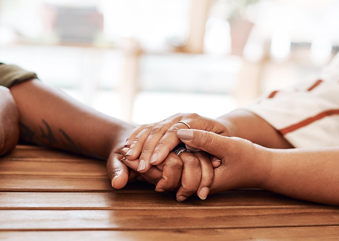 A couple's hands holding each other as an act of empathy.
