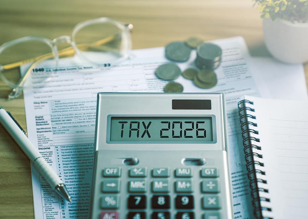 Calculator showing 'tax 2026' over tax documents.