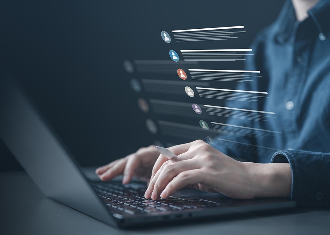 Person typing on a laptop illustrated with a list of contacts software graphics.