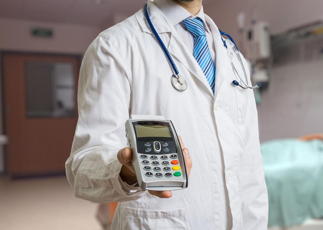 A doctor holding a payment terminal.