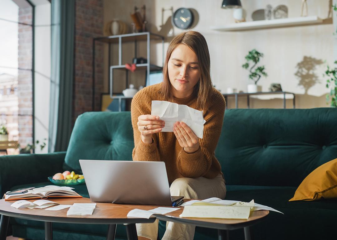 Woman at home looking at receipts.