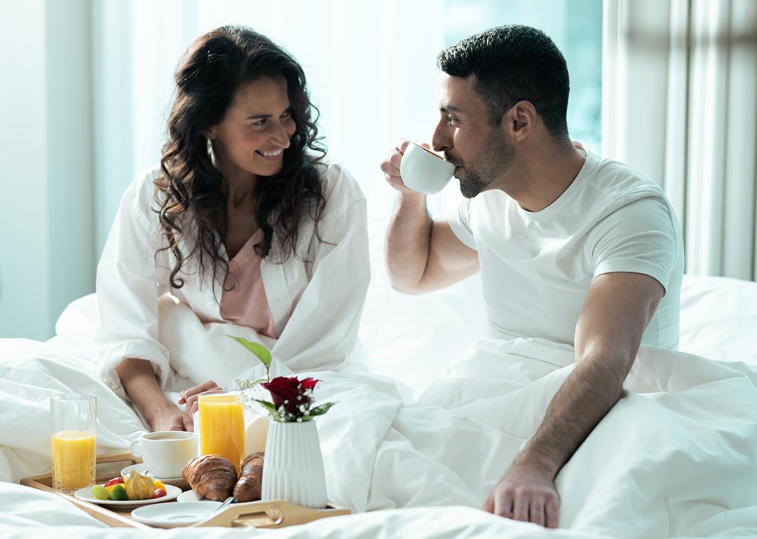 A young couple having breakfast in bed during their honeymoon.