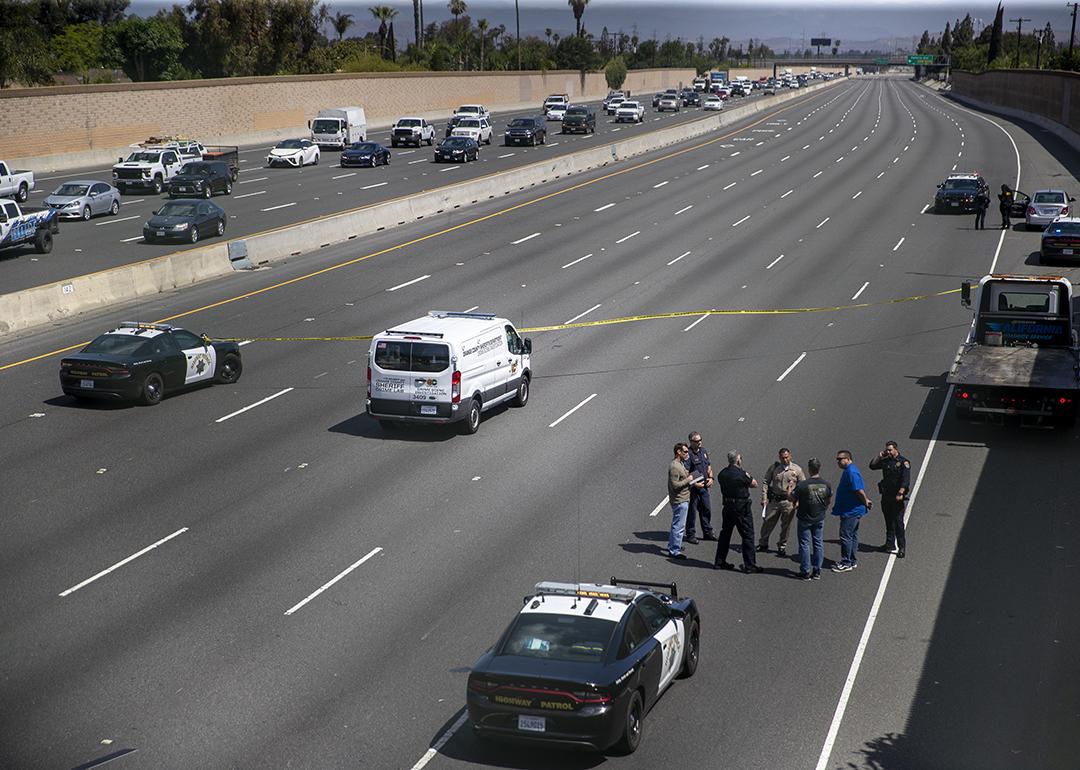 Crime scene investigators gather on the side of California Highway where a 6-year-old boy was fatally shot during a road rage incident on 55 Freeway in Orange.