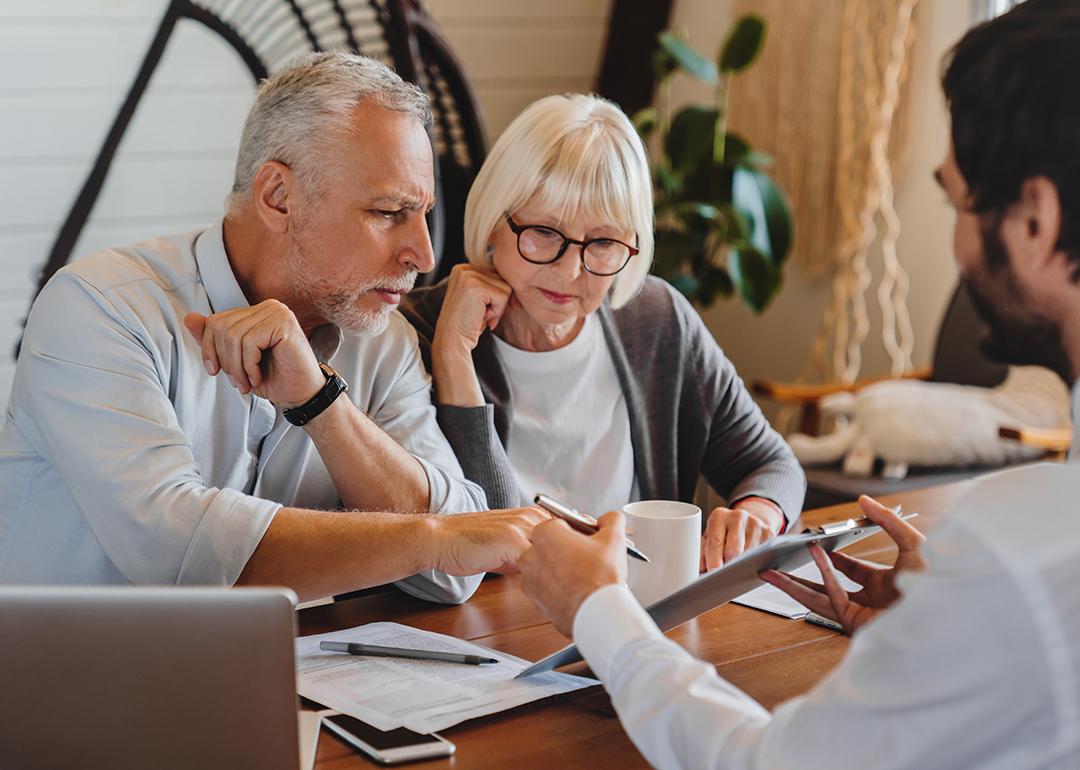 A senior couple consulting with a real estate professional.