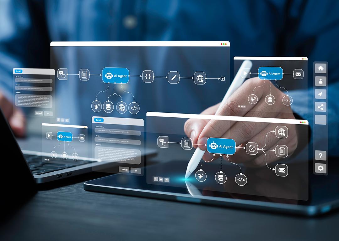 AI workflow automation graphics over a person using a laptop and digital tablet at work.
