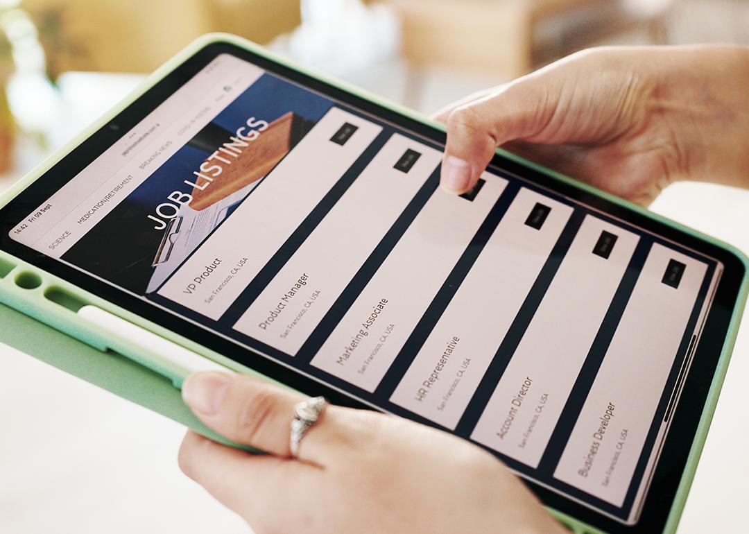 Person browsing job listings online using a tablet.
