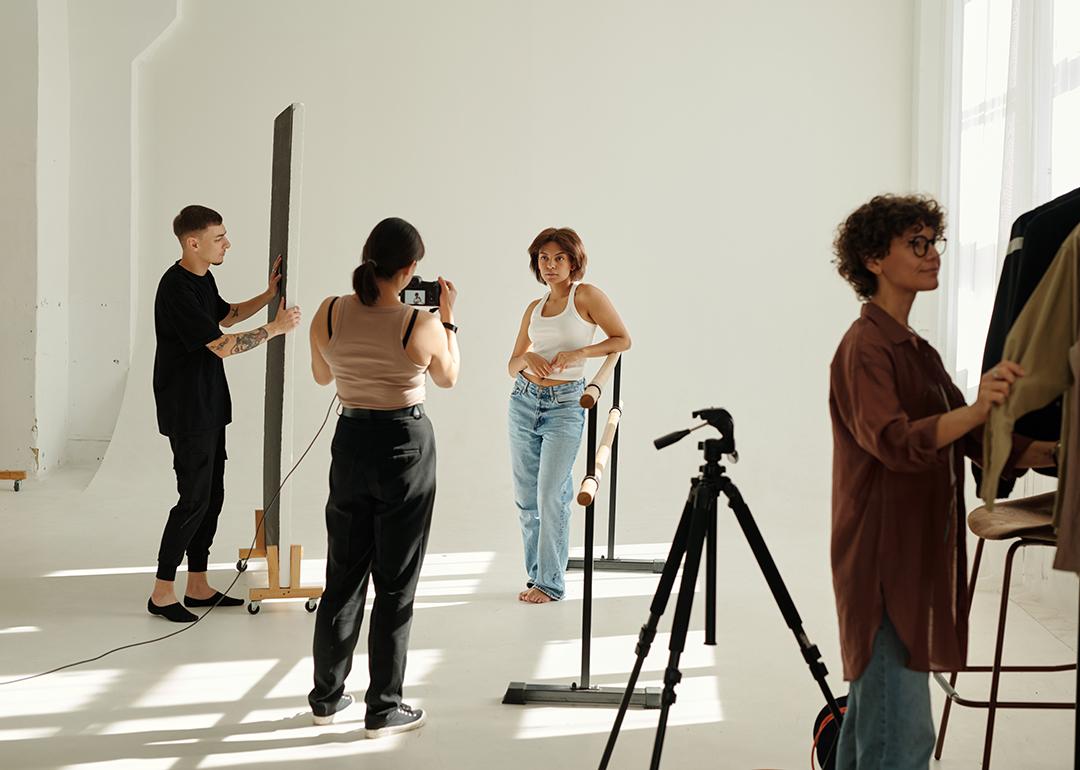 A creative team photographing a fashion model in a studio.