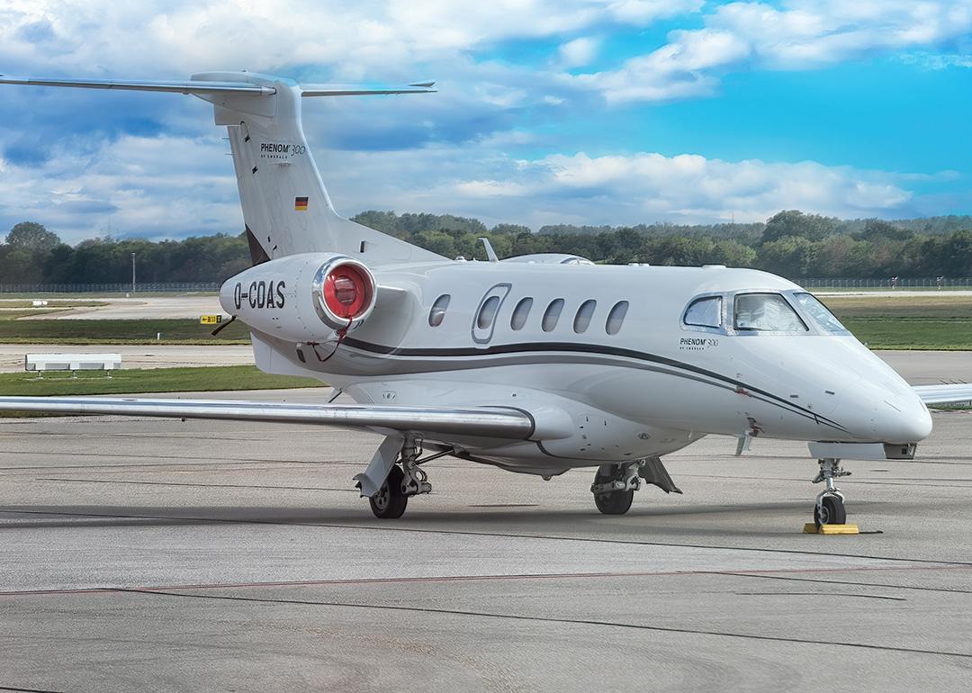 A Phenom 300 aircraft at an airport getting ready for a flight.