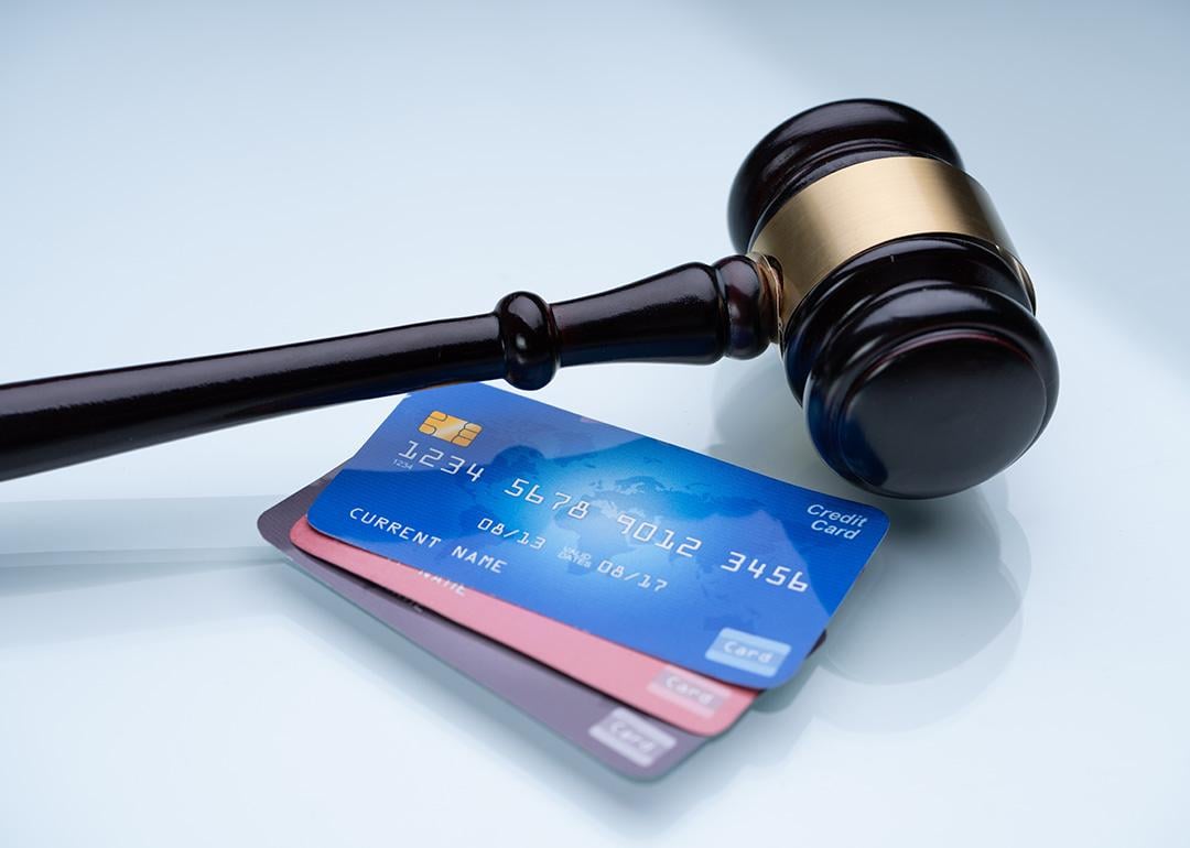 A gavel and a few credit cards laid on a table.