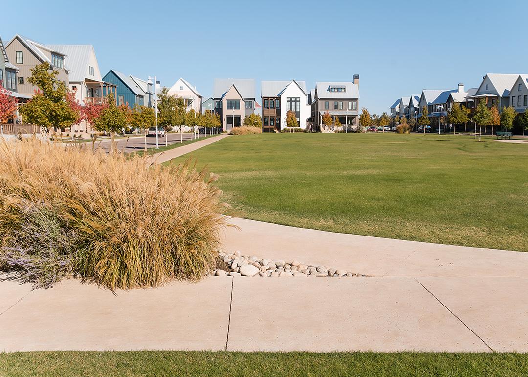 Grassy neighborhood park surrounded by modern homes and sidewalks in Oklahoma City.