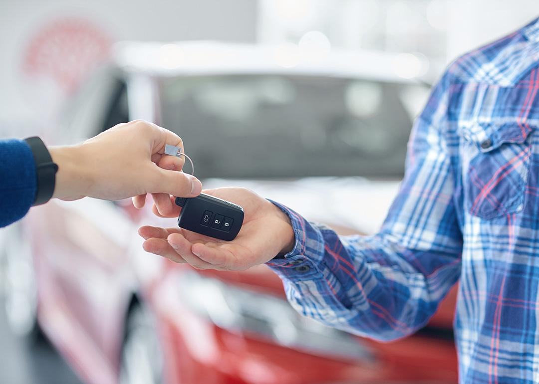 Customer taking new car keys after purchase.