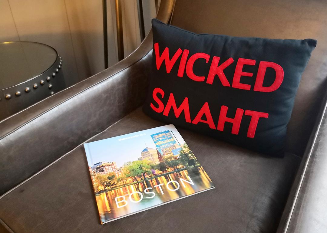 A 'wicked smaht' pillow merchandise beside a travel magazine about Boston, Massachusetts.