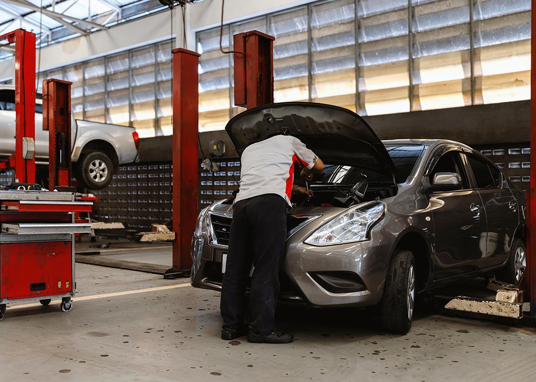A car technician working on maintenance of a car engine.