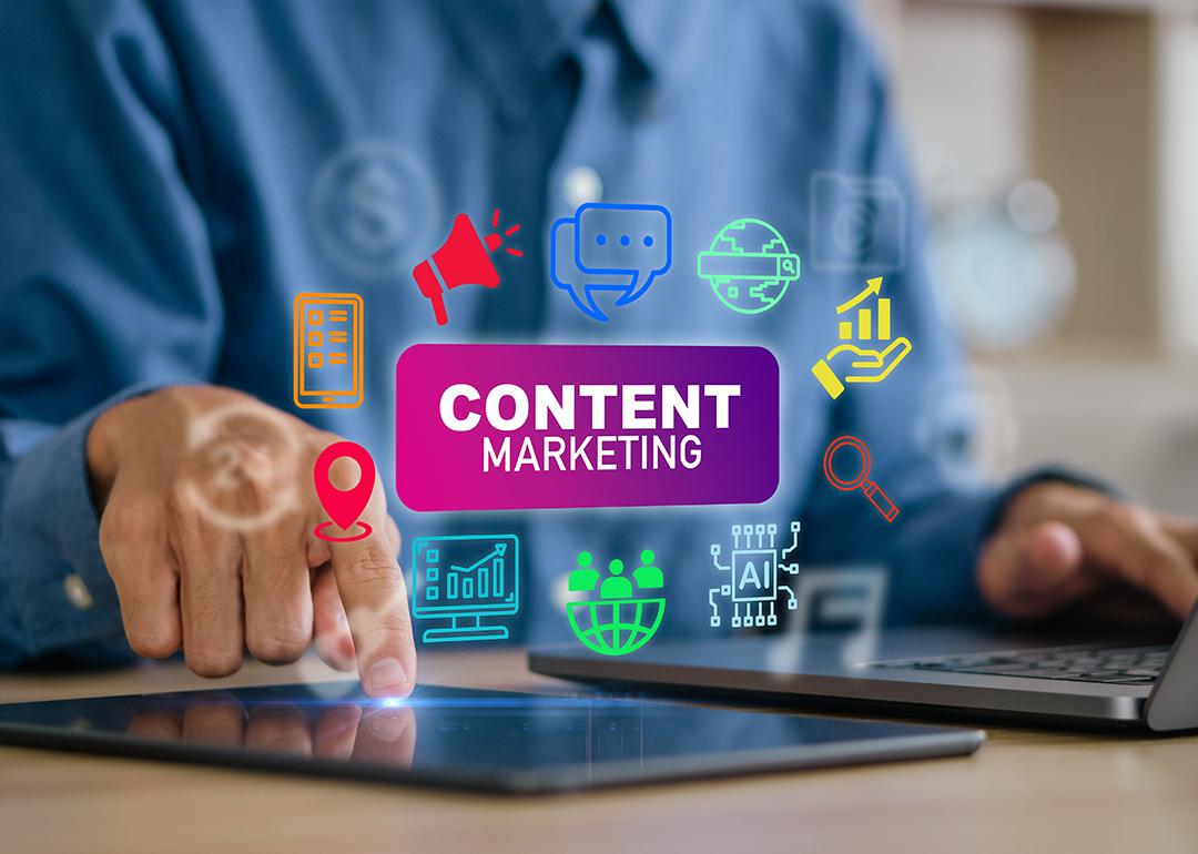 A content creator using a laptop and tablet with content marketing concept icons.