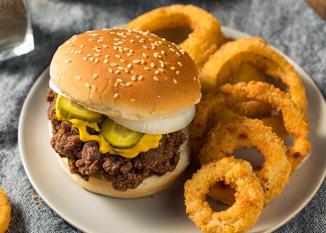Homemade slug burgers with pickles and onion rings on the side.