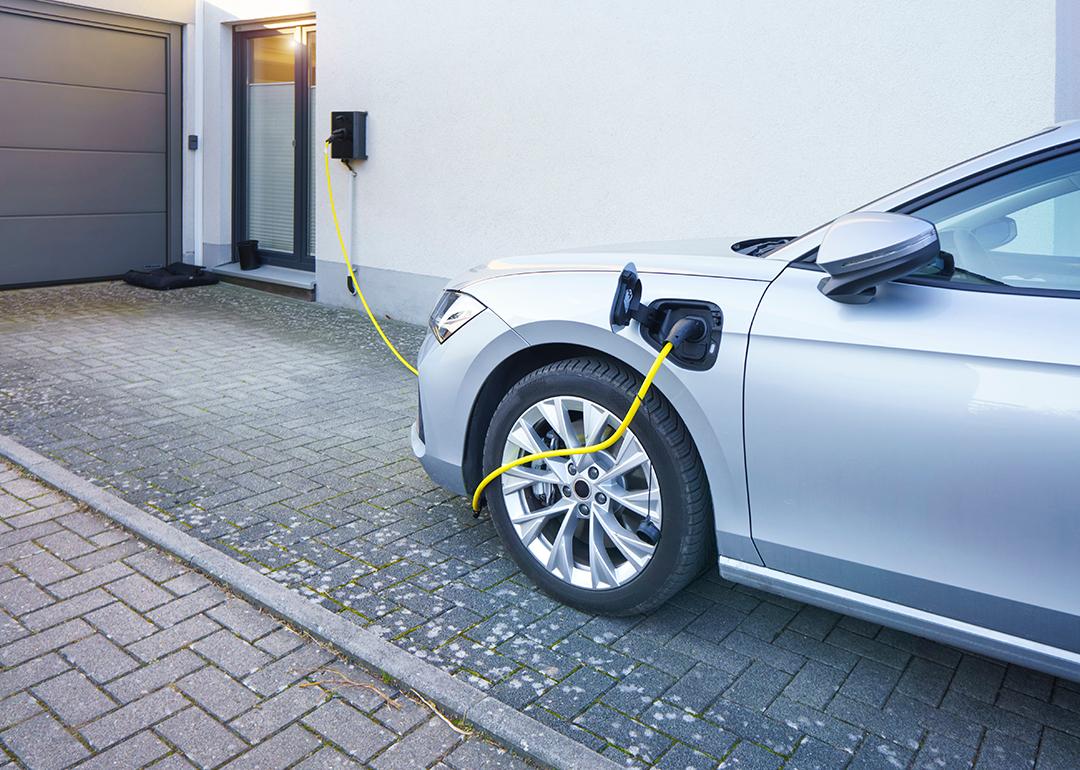 A car connected to an EV charger at home installed in the driveway.