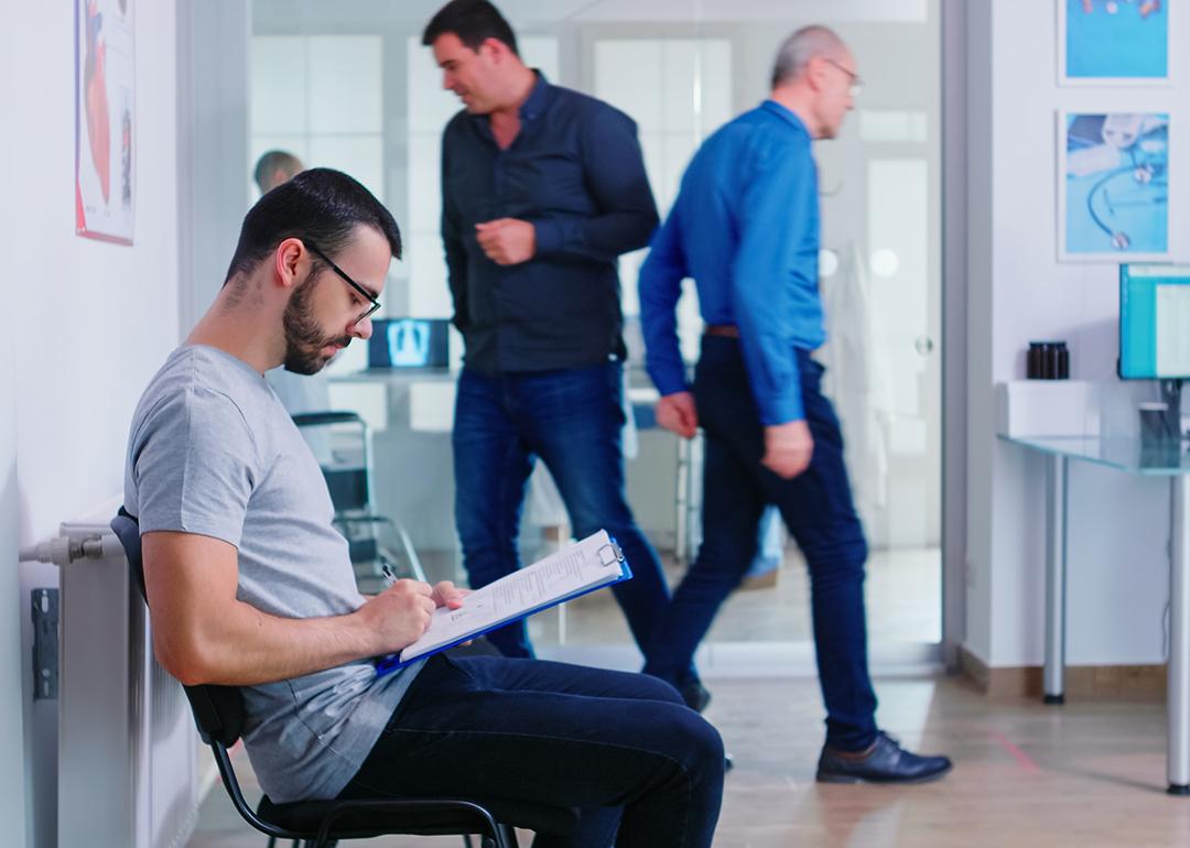 A person filing a document in a hospital waiting area.