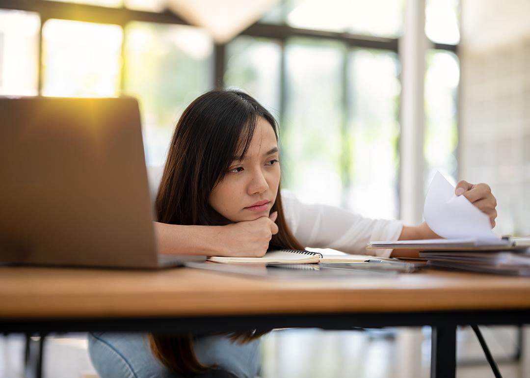 A tired employee looking though a paperwork in the office.