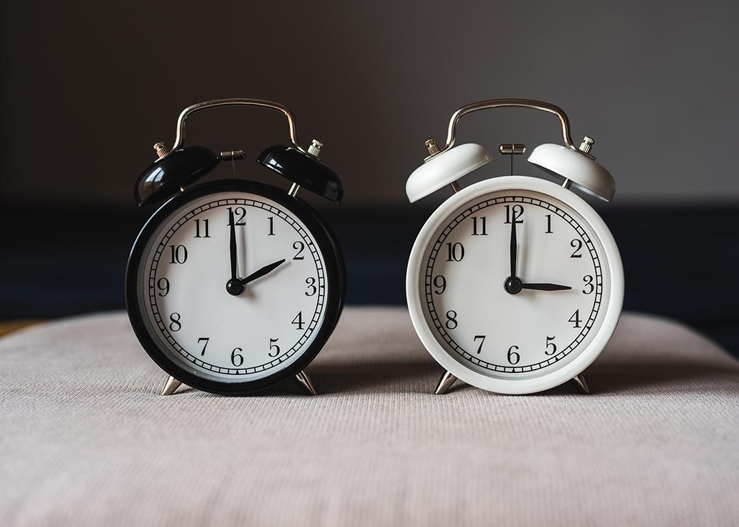 Two retro table clocks representing daylight savings time.