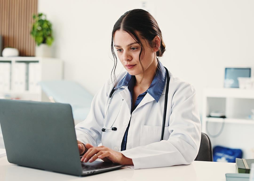 A female doctor using a laptop for a telehealth consultation.