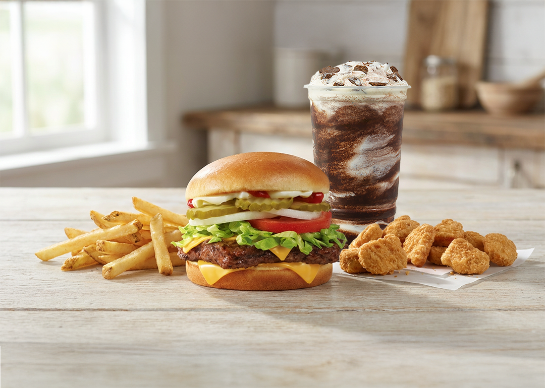 A burger meal with fries, chicken nuggets, and frosty drink.