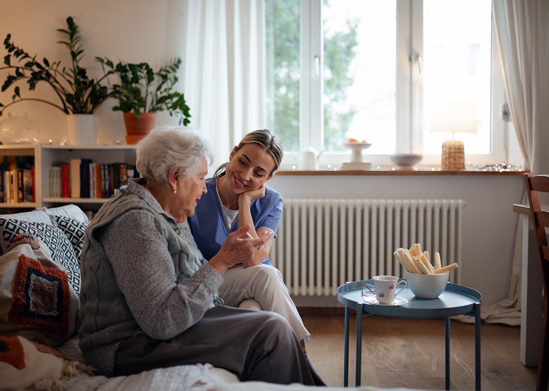 A senior woman accompanied by her caregiver at home.