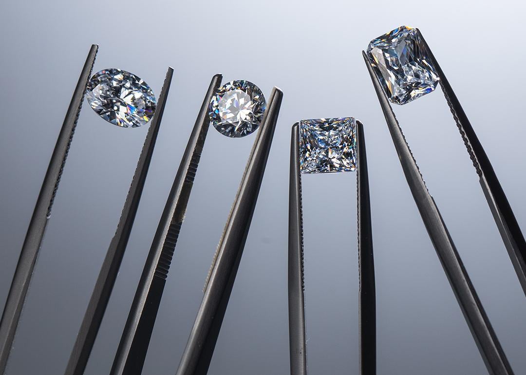 Close up of lab grown diamonds held by tweezers.
