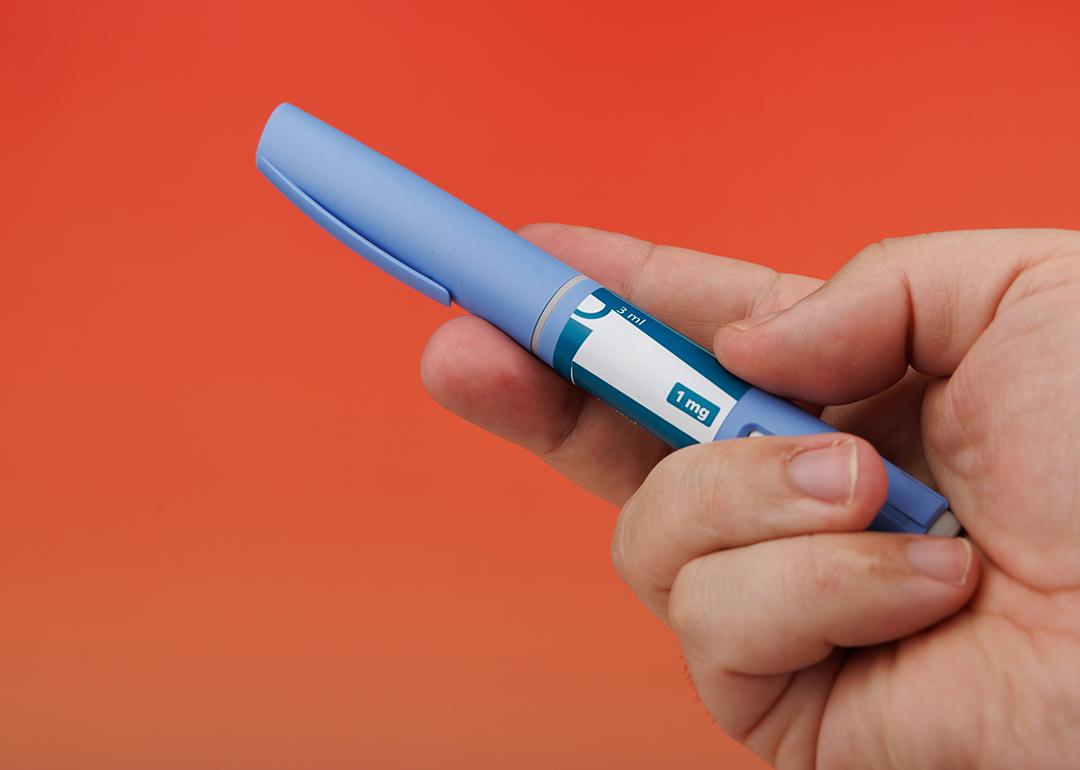 Person's hand holding a semaglutide pen.