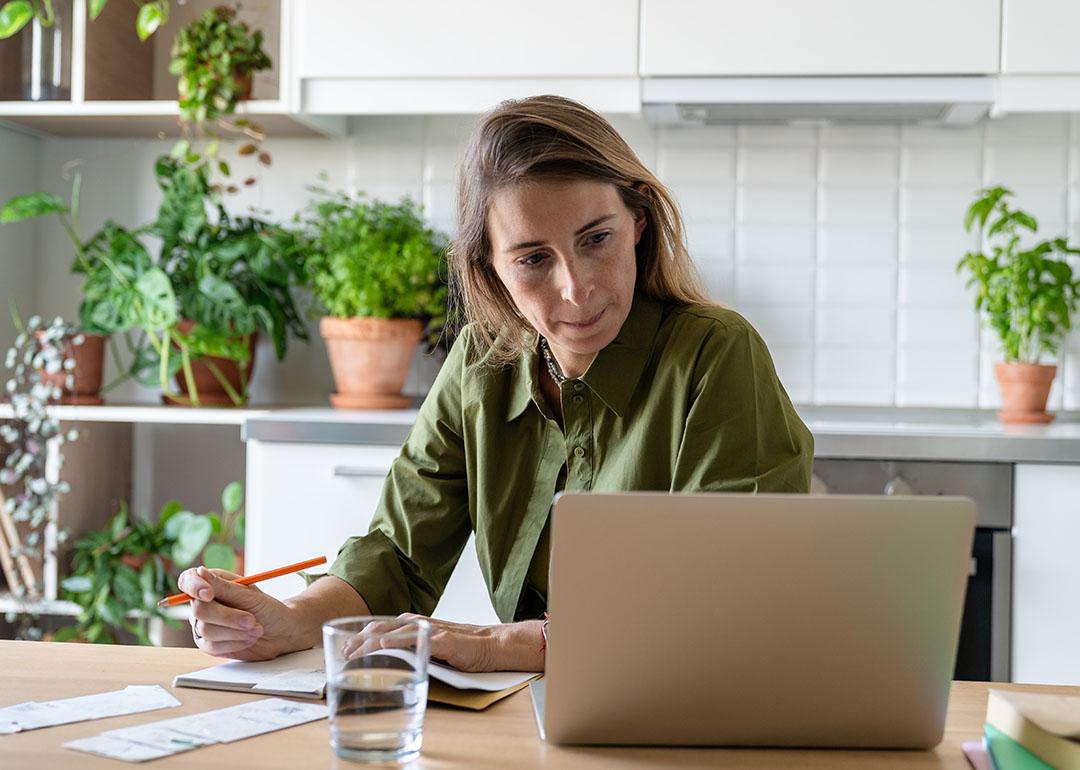 A female homeowner focused on reviewing documents at home.
