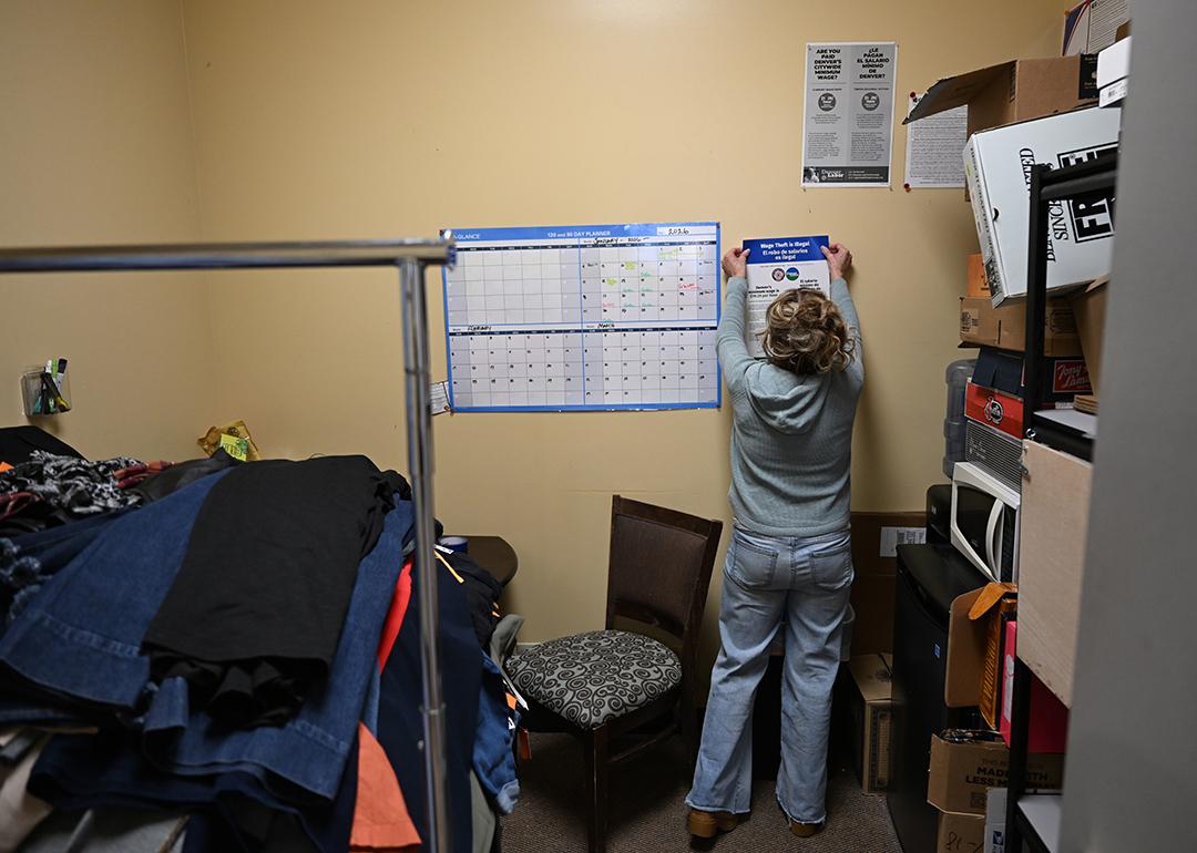 Denver Labor and Auditor's Office staff hangs a poster about wage changes.
