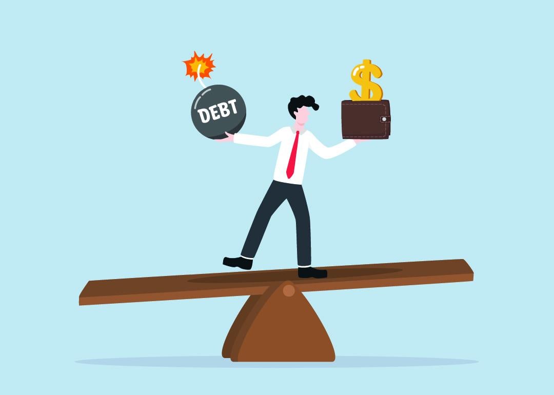 A vector illustration showing a person balancing on a seesaw of a debt bomb and a money wallet.
