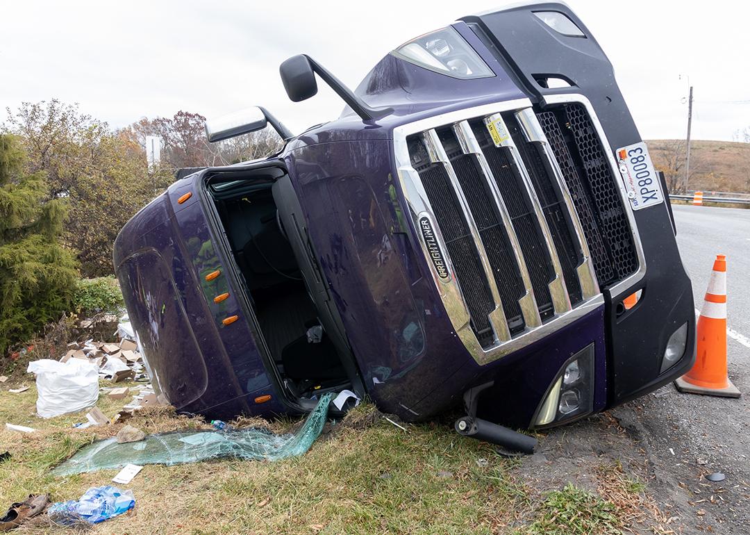 An overturned truck at the side of a road after an accident. 