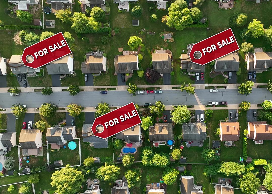 A top aerial view of a neighborhood with some homes marked ‘For Sale.’