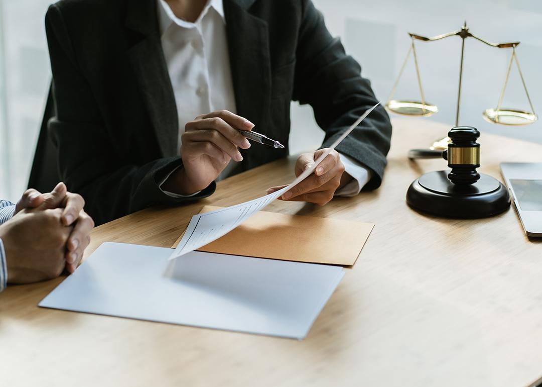 A legal counsel presenting a contract to a client in a law office.