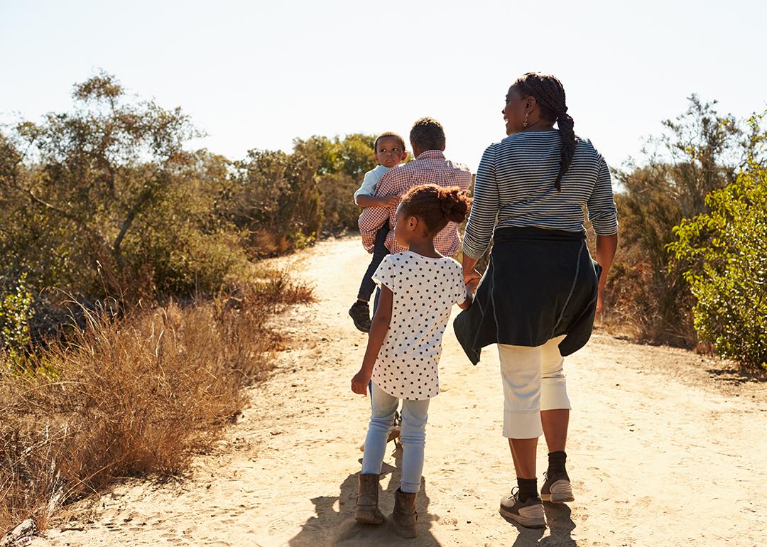Grandparents walking outdoors with their grandchildren.