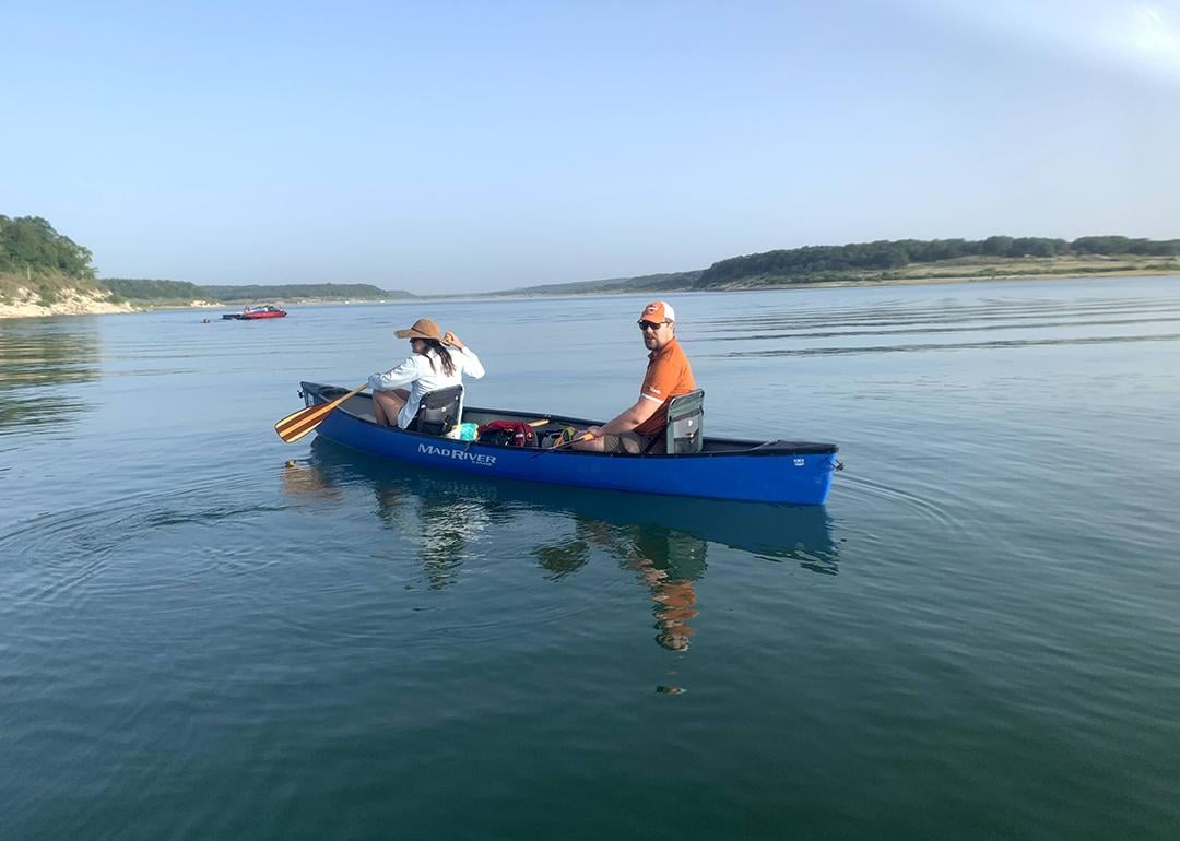 Two people on a boat on a lake.