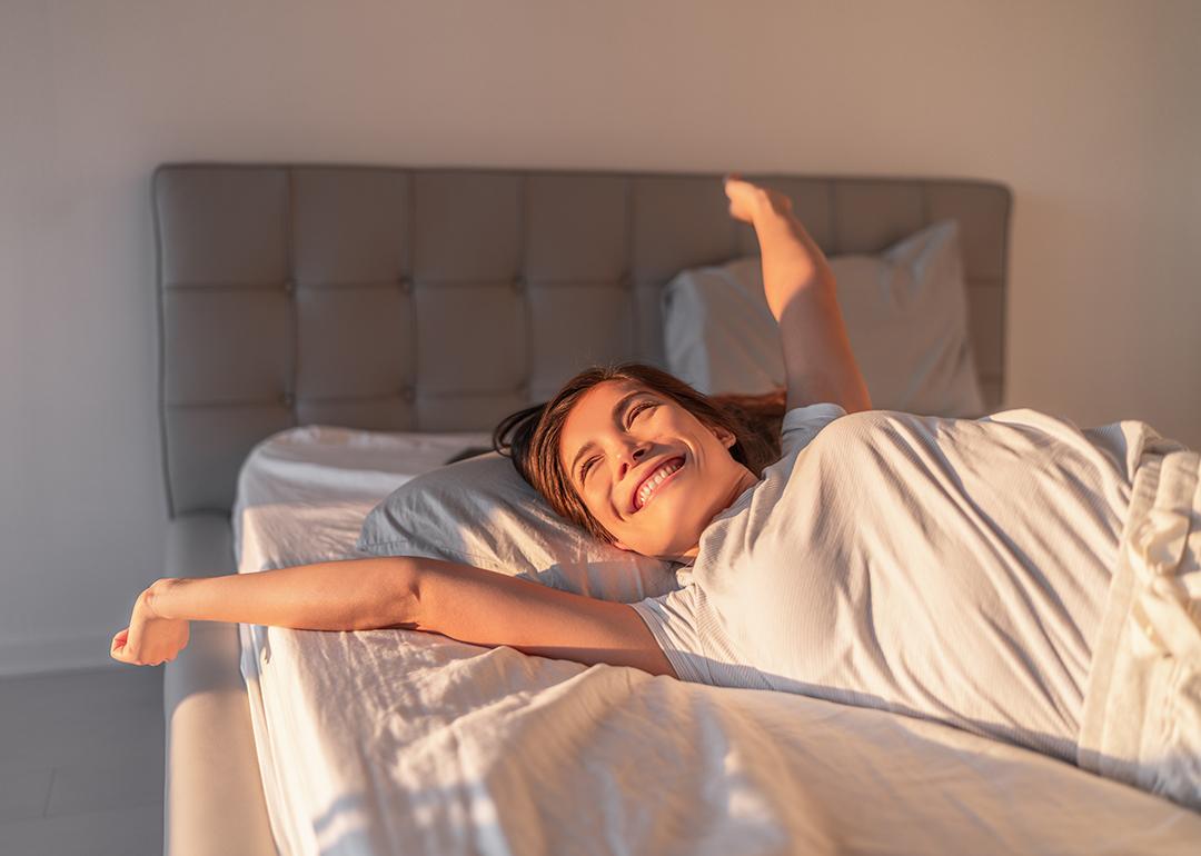 A happy young woman waking up in the morning.