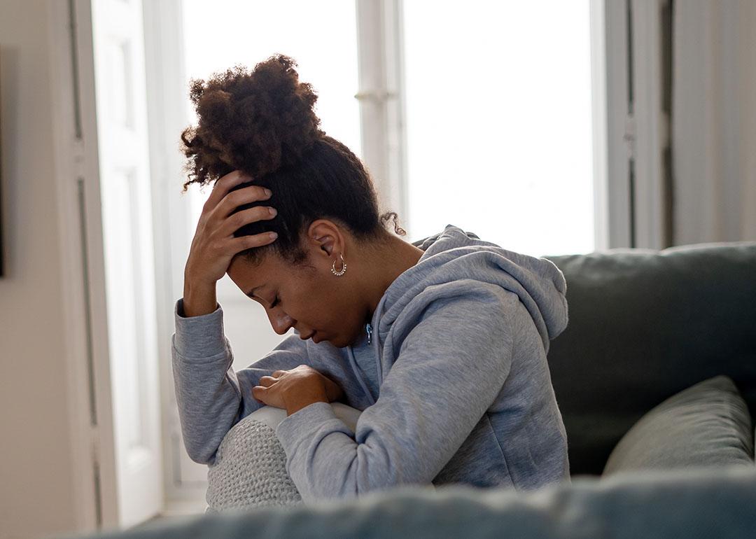 A young black woman experiencing headache at home.
