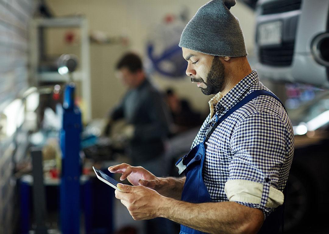 A mechanic using a tablet to process an order.