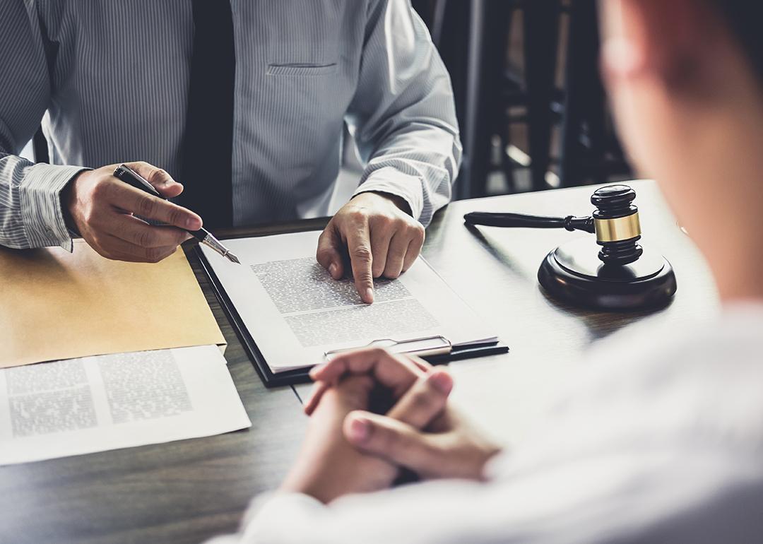 A lawyer consulting with his client and reviewing documents.