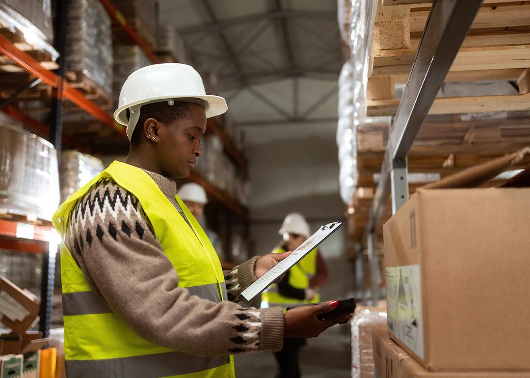 A worker doing a package inventory in a distribution warehouse.