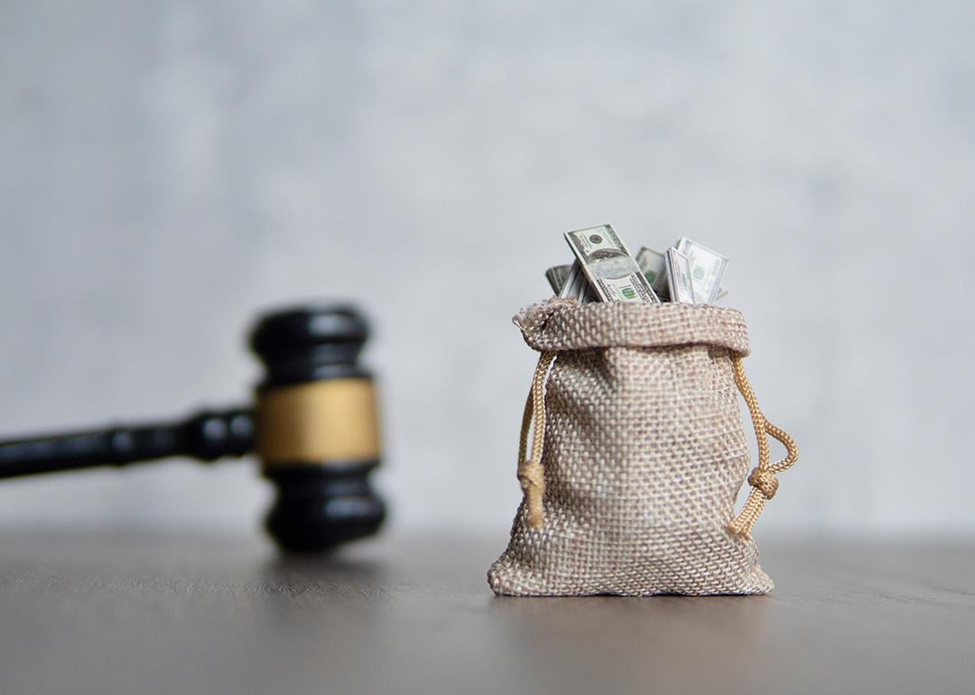 A small bag of money and a judge's gavel as a concept of penalty in lawsuit.