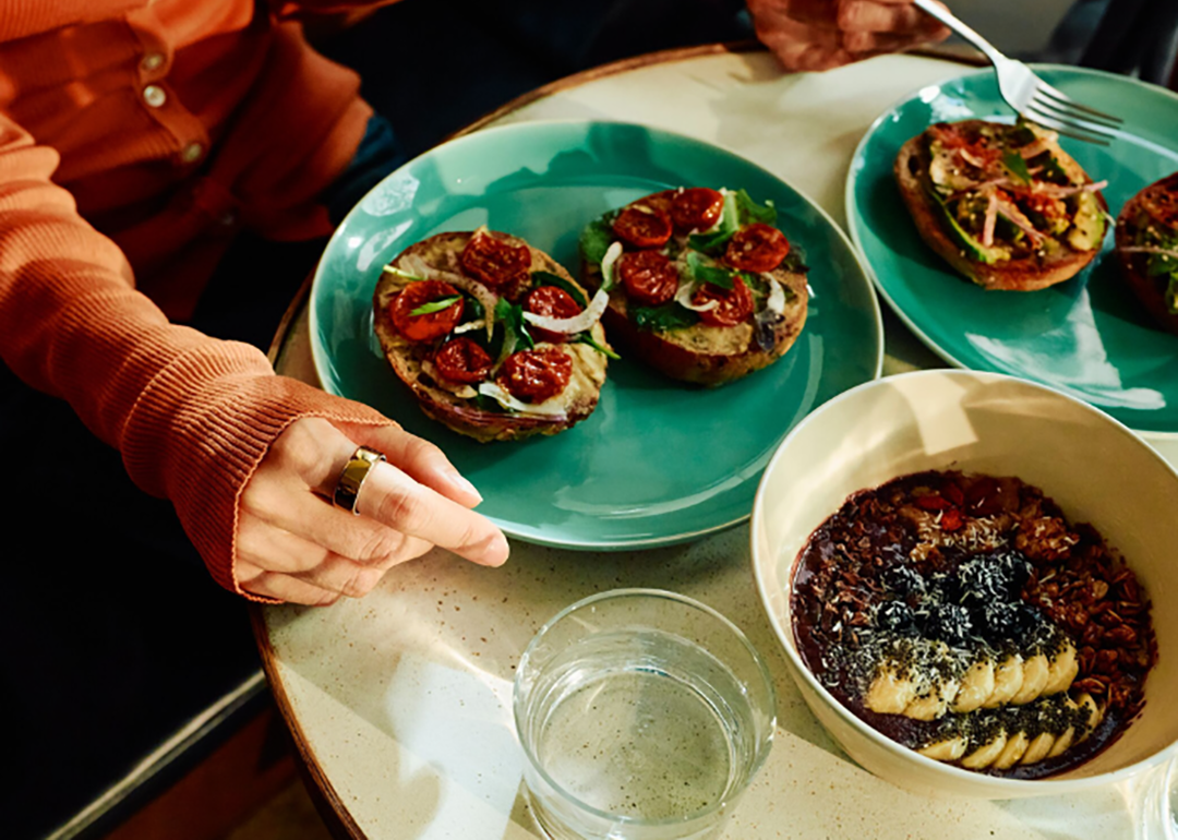 Plates of special bagels and a healthy oat meal served on a table.